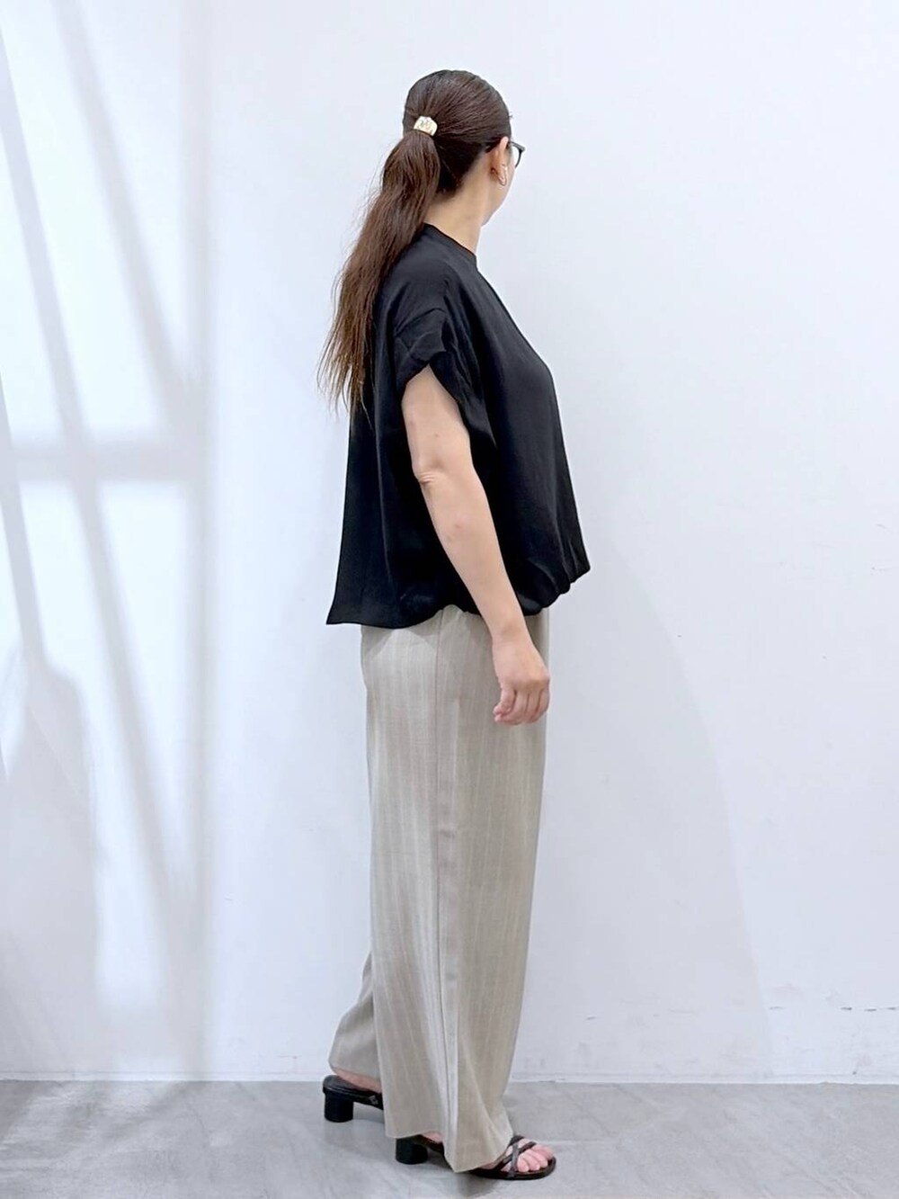 ブラック系のTシャツ/カットソー、ブラック系のサンダル、ブラック系のかごバッグを着用したレディースの夏コーディネートの5枚目の写真