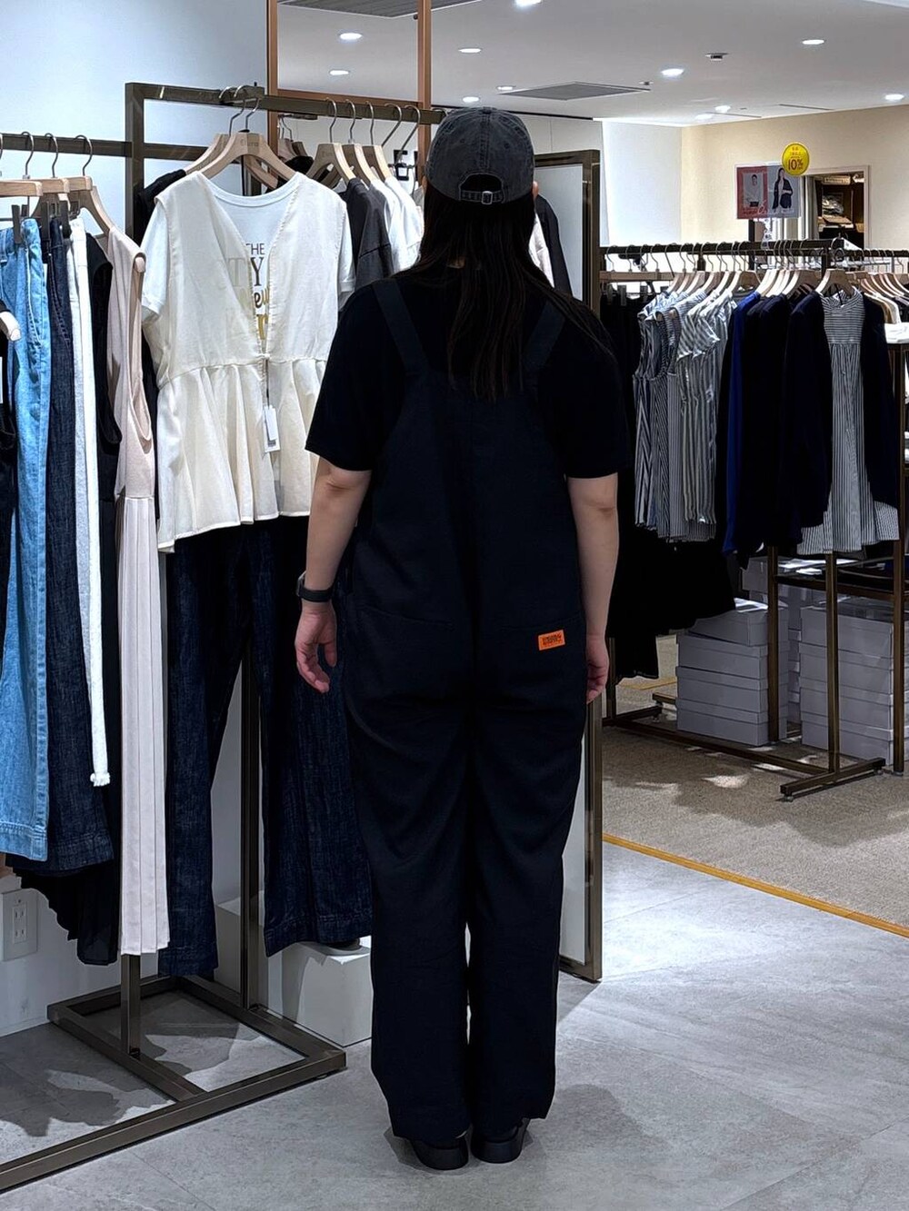 ブラック系のサンダル、ブラック系のニット/セーター、ブラック系のサロペット/オーバーオールを着用したレディースの春コーディネートの4枚目の写真