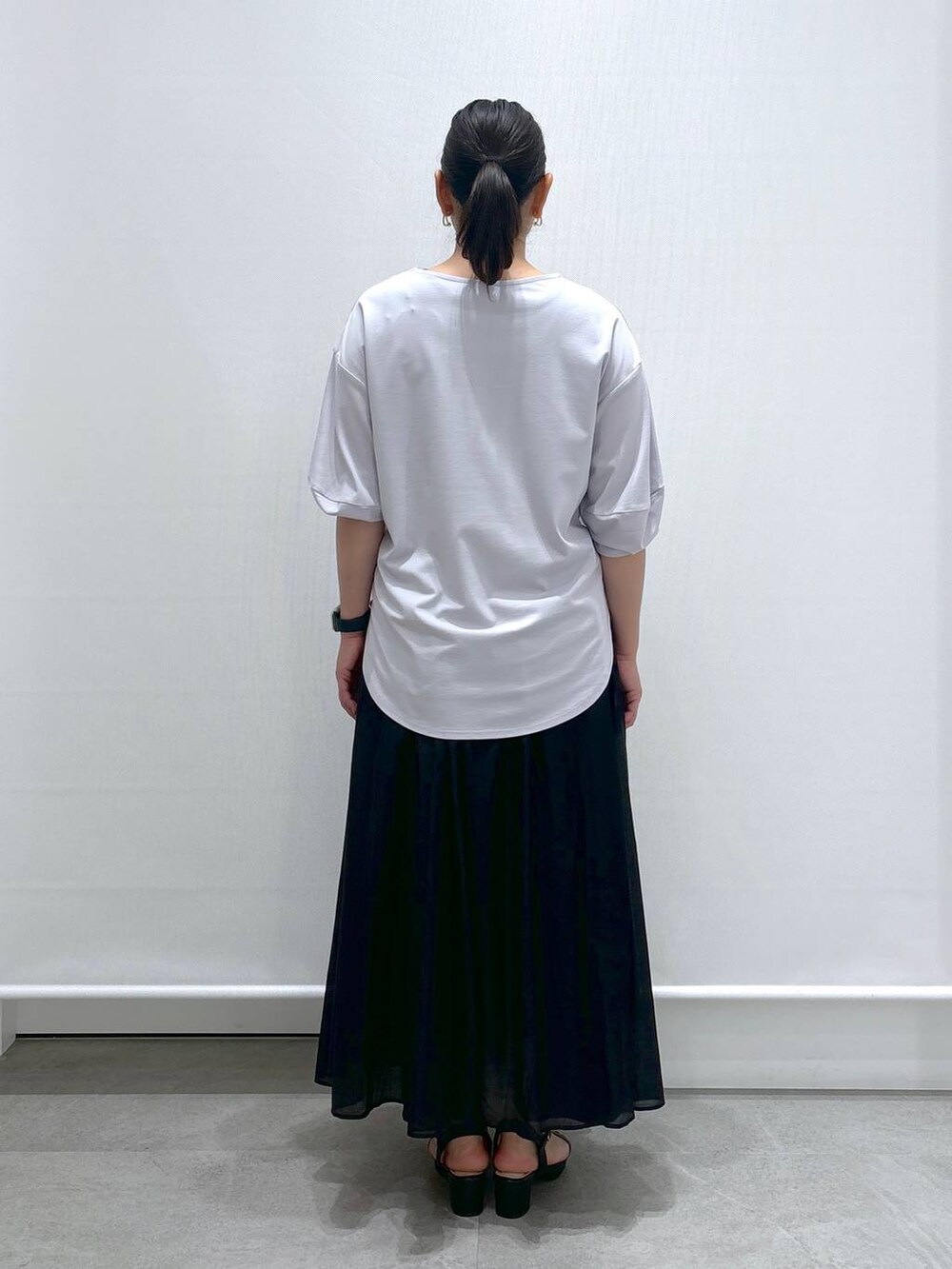 グレー系のTシャツ/カットソー、ブラック系のサンダル、ブラック系のスカートを着用したレディースの夏コーディネートの4枚目の写真