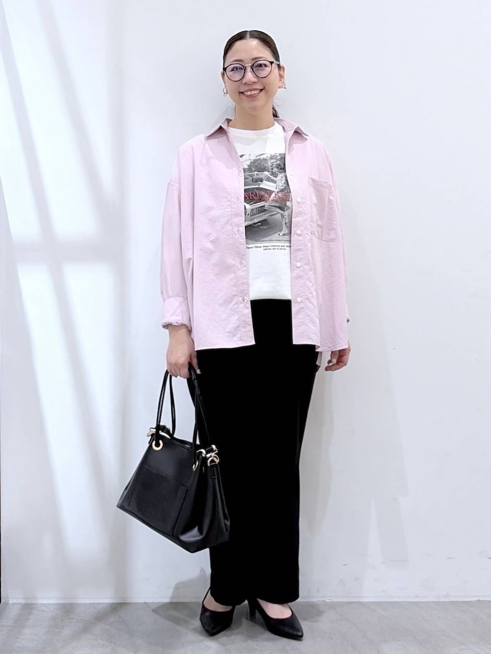 ブラック系のその他パンツ、ブラック系のトートバッグ、ピンク系のシャツ/ブラウスを着用したレディースの春コーディネートの2枚目の写真