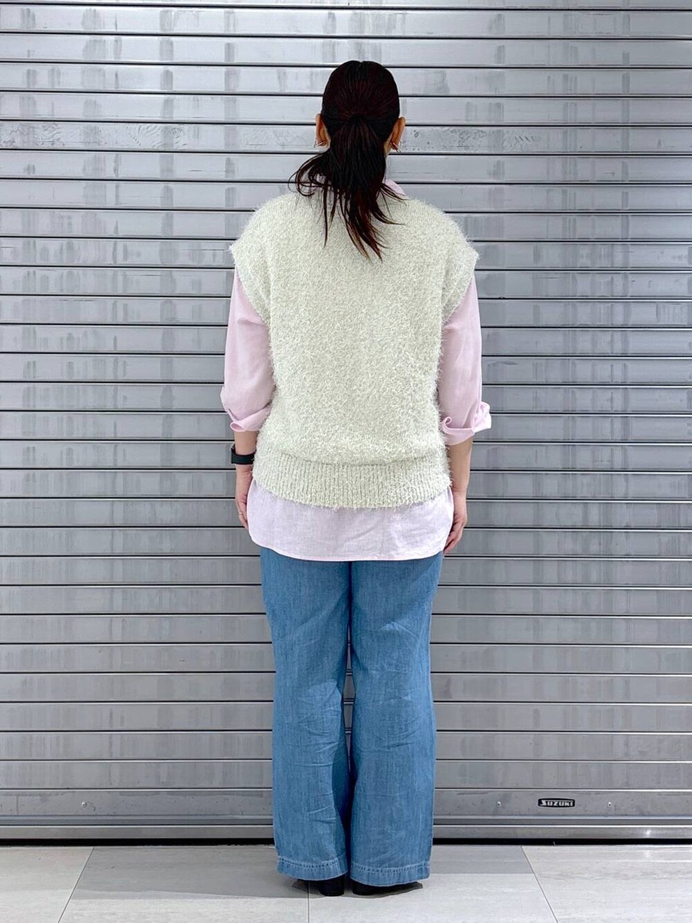 ピンク系のシャツ/ブラウス、ホワイト系のベスト、ブラック系のハンドバッグを着用したレディースの春コーディネートの4枚目の写真