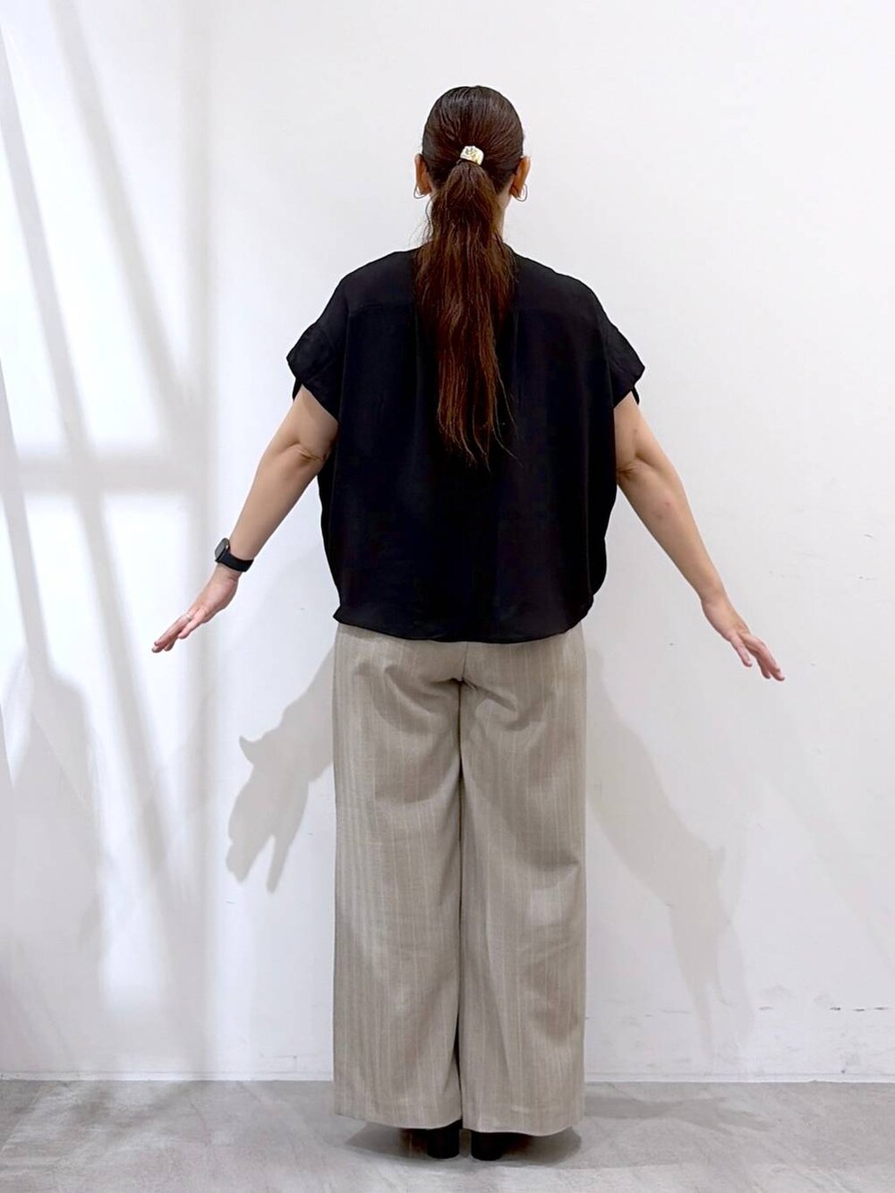 ブラック系のTシャツ/カットソー、ブラック系のサンダル、ブラック系のかごバッグを着用したレディースの夏コーディネートの4枚目の写真