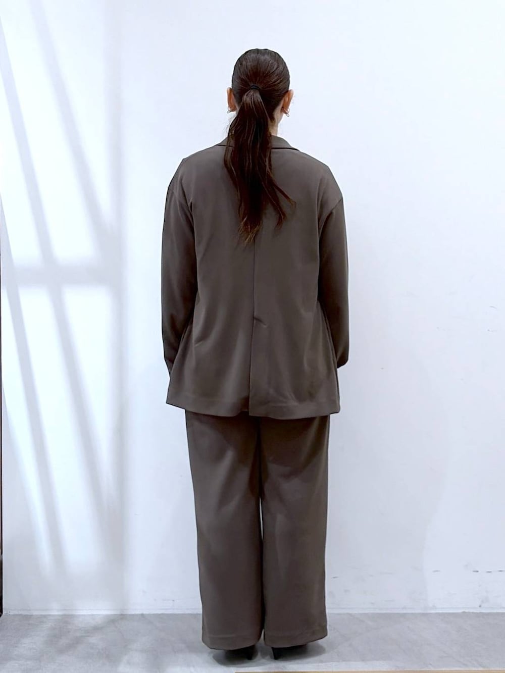 ブラウン系のその他パンツ、ブラック系のハンドバッグ、ブラウン系のテーラードジャケットを着用したレディースの春コーディネートの4枚目の写真