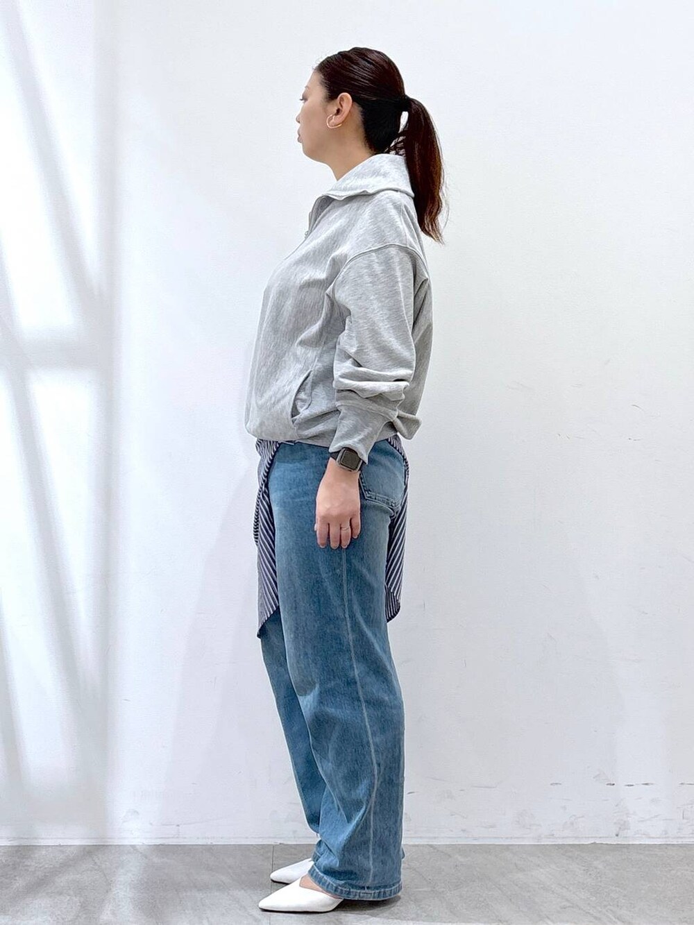 ホワイト系のハンドバッグ、ブルー系のデニムパンツ、グレー系のTシャツ/カットソーを着用したレディースの春コーディネートの3枚目の写真
