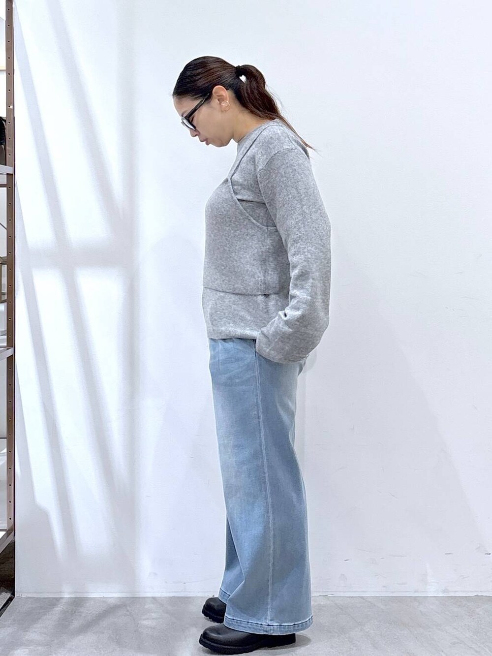 ブラック系のブーツ、ブルー系のデニムパンツ、グレー系のニット/セーターを着用したレディースの冬コーディネートの3枚目の写真
