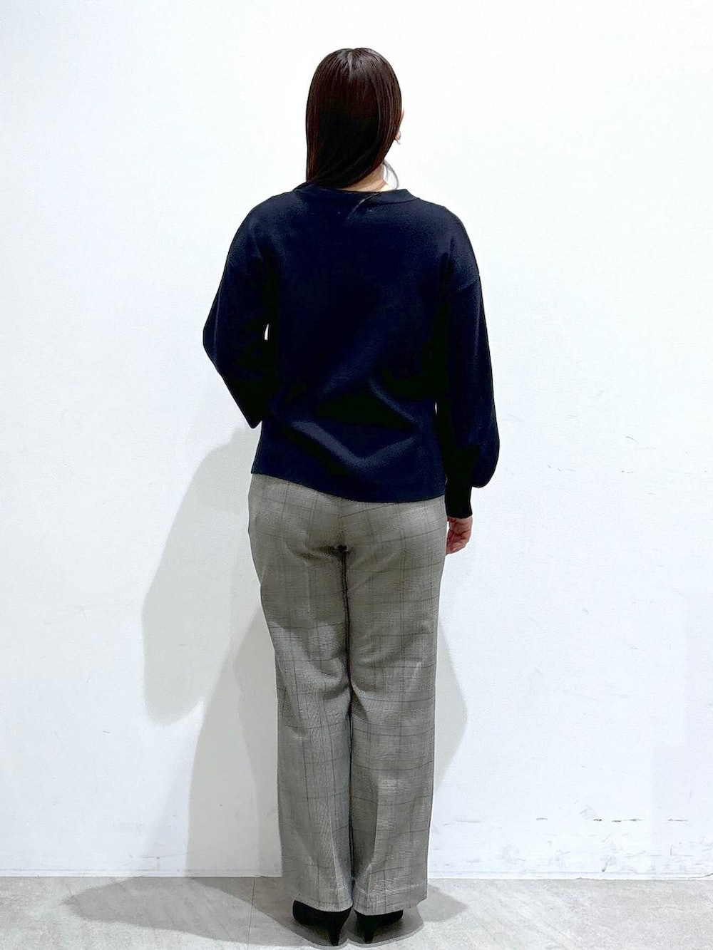 ブラック系のトートバッグ、ブルー系のニット/セーター、ブラック系のパンプスを着用したレディースの冬コーディネートの4枚目の写真