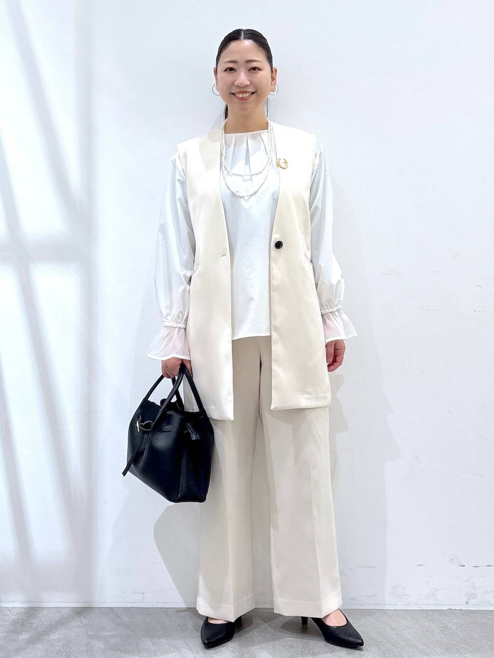 ホワイト系のその他パンツ、ホワイト系のスーツベスト、ホワイト系のシャツ/ブラウスを着用したレディースの冬コーディネートの2枚目の写真