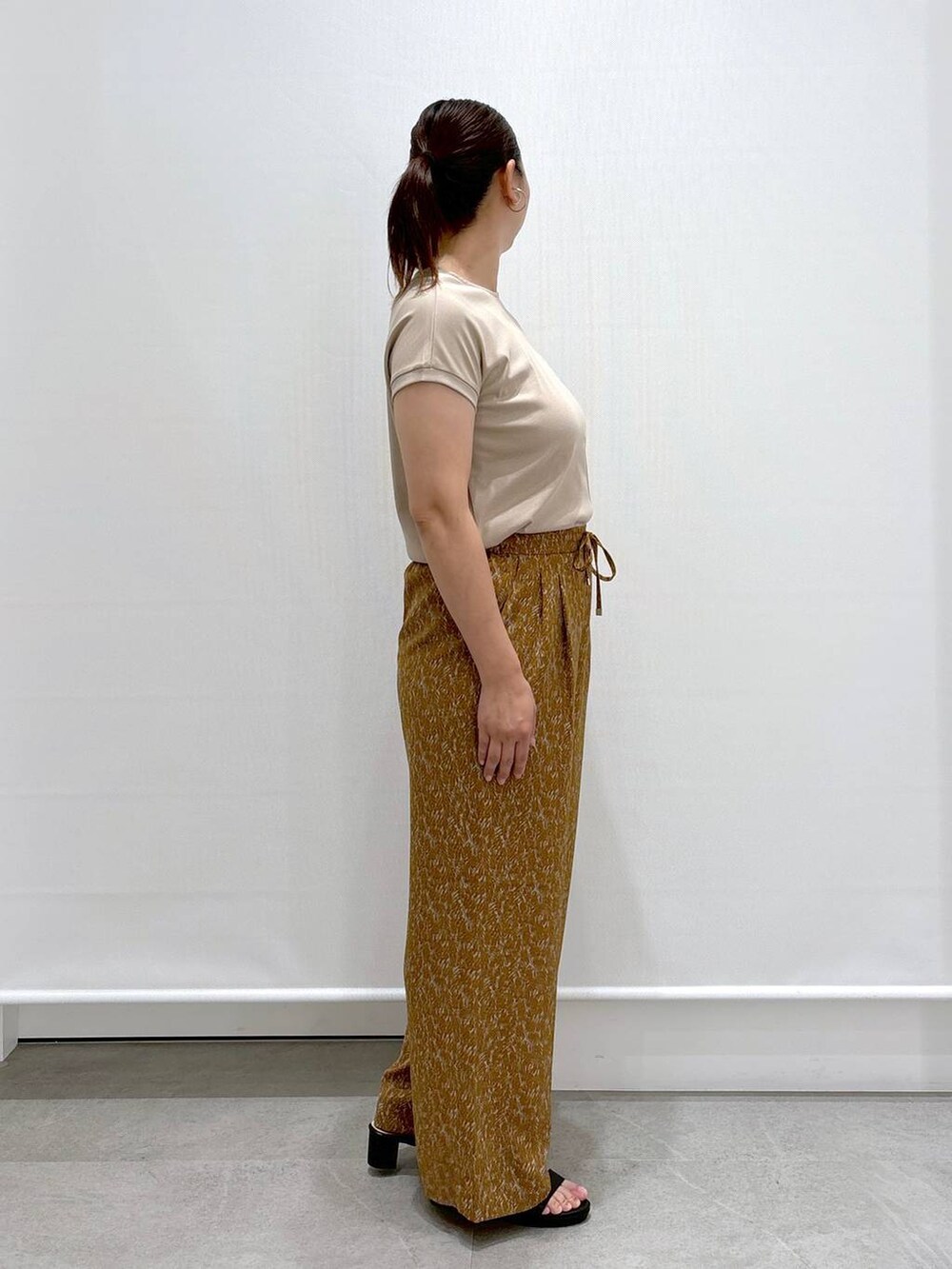 ベージュ系のTシャツ/カットソー、ブラック系のハンドバッグ、ブラウン系のその他パンツを着用したレディースの夏コーディネートの5枚目の写真