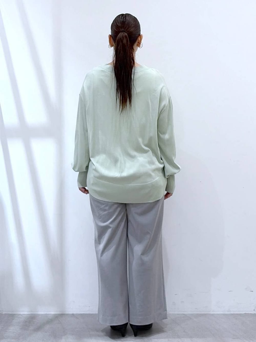 ホワイト系のタンクトップ、ブラック系のハンドバッグ、グレー系のその他パンツを着用したレディースの春コーディネートの4枚目の写真