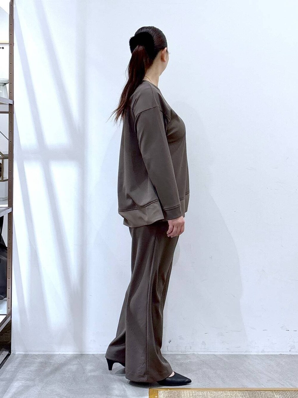 ブラウン系のその他パンツ、ブラウン系のTシャツ/カットソー、ブラック系のハンドバッグを着用したレディースの冬コーディネートの5枚目の写真