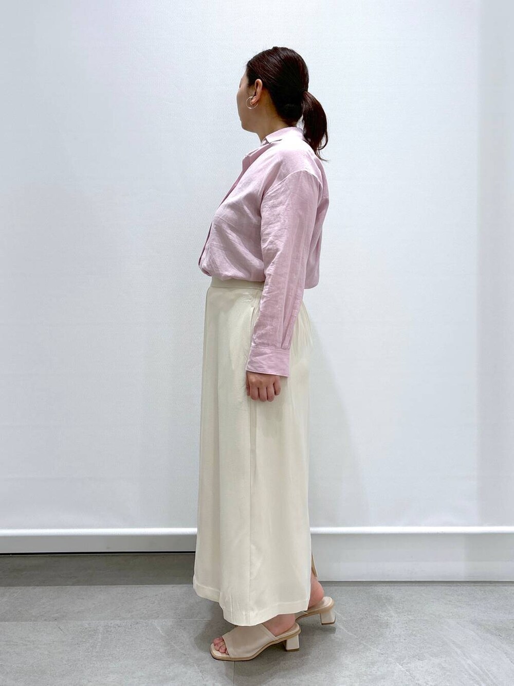 ピンク系のシャツ/ブラウス、ホワイト系のサンダル、ホワイト系のハンドバッグを着用したレディースの春コーディネートの3枚目の写真