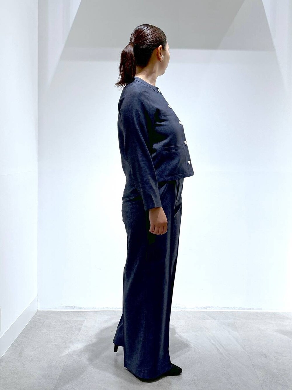 ブルー系のデニムパンツ、ブルー系のデニムパンツ、ブラック系のパンプスを着用したレディースの秋コーディネートの5枚目の写真