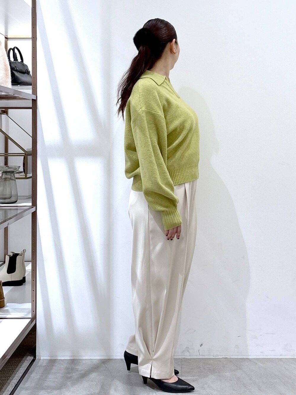 ブラック系のパンプス、ホワイト系のその他パンツ、イエロー系のニット/セーターを着用したレディースの冬コーディネートの6枚目の写真