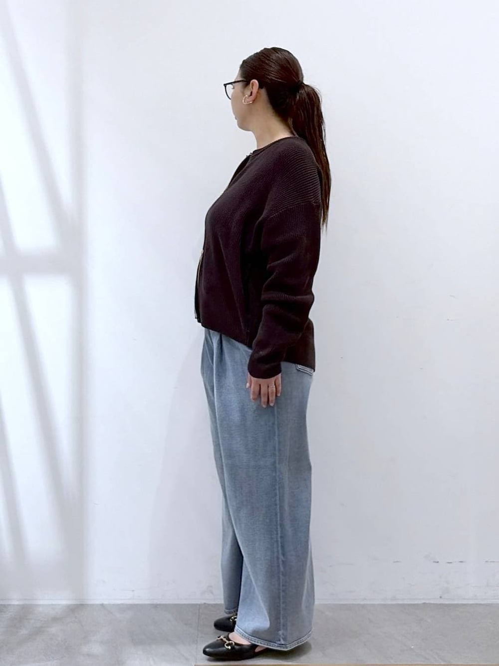 ホワイト系のタンクトップ、ブルー系のデニムパンツ、ブラック系のパンプスを着用したレディースの春コーディネートの3枚目の写真