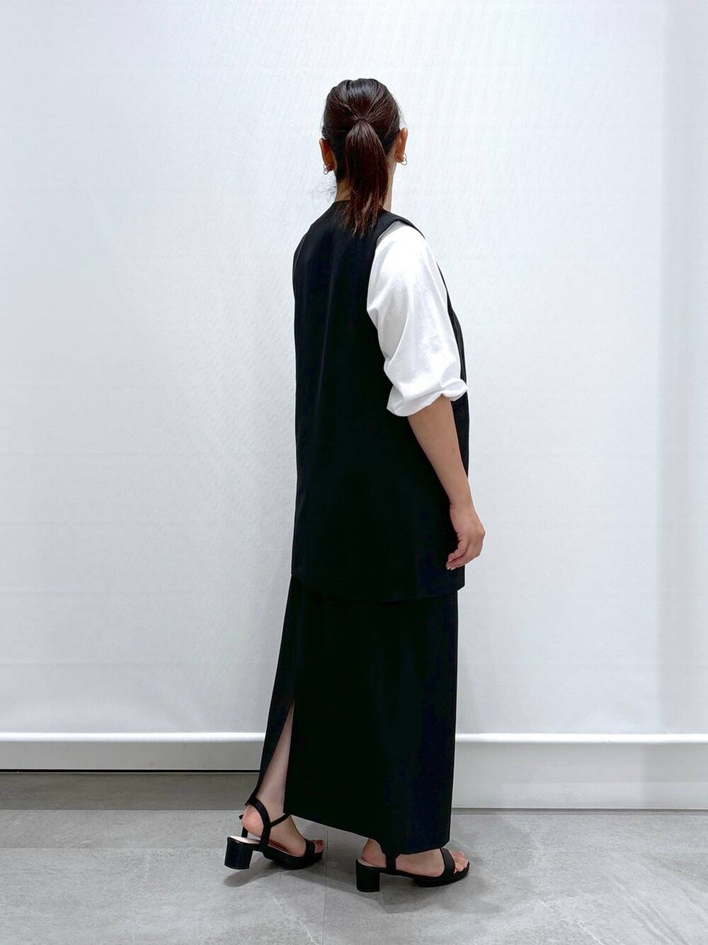 ブラック系のトートバッグ、ブラック系のサンダル、ブラック系のスカートを着用したレディースの秋コーディネートの5枚目の写真