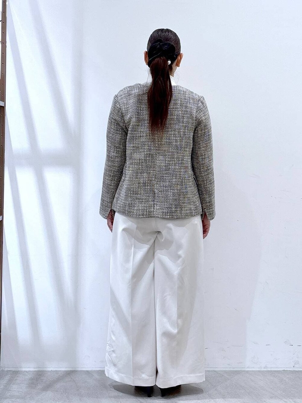 ブラック系のハンドバッグ、ブラック系のノーカラージャケット、ホワイト系のシャツ/ブラウスを着用したレディースの冬コーディネートの4枚目の写真