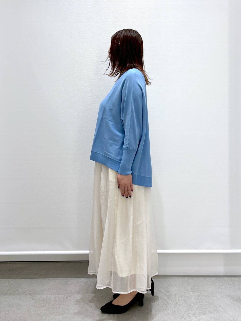 ホワイト系のスカート、ブラック系のショルダーバッグ、ブラック系のパンプスを着用したレディースの春コーディネートの3枚目の写真