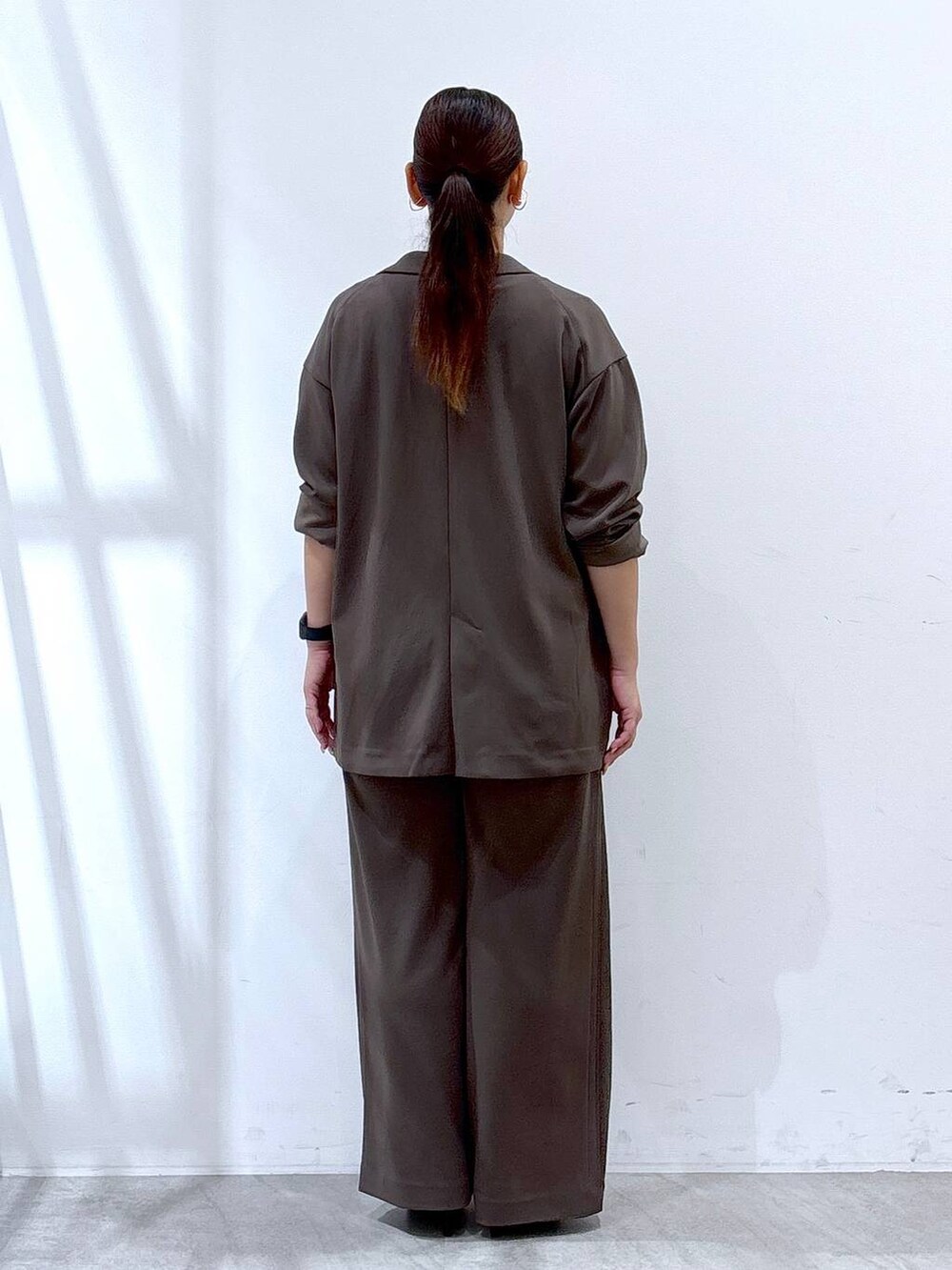 ブラック系のパンプス、ブラック系のハンドバッグ、ブラウン系のその他パンツを着用したレディースの秋コーディネートの4枚目の写真