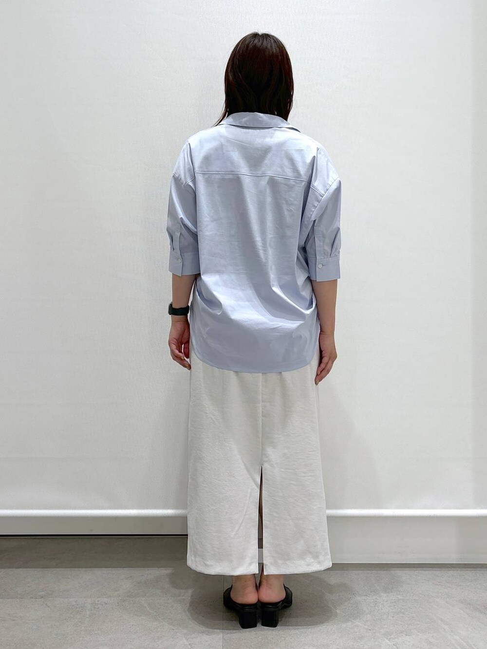 ブラック系のサンダル、ブラック系のハンドバッグ、ブルー系のシャツ/ブラウスを着用したレディースの夏コーディネートの3枚目の写真