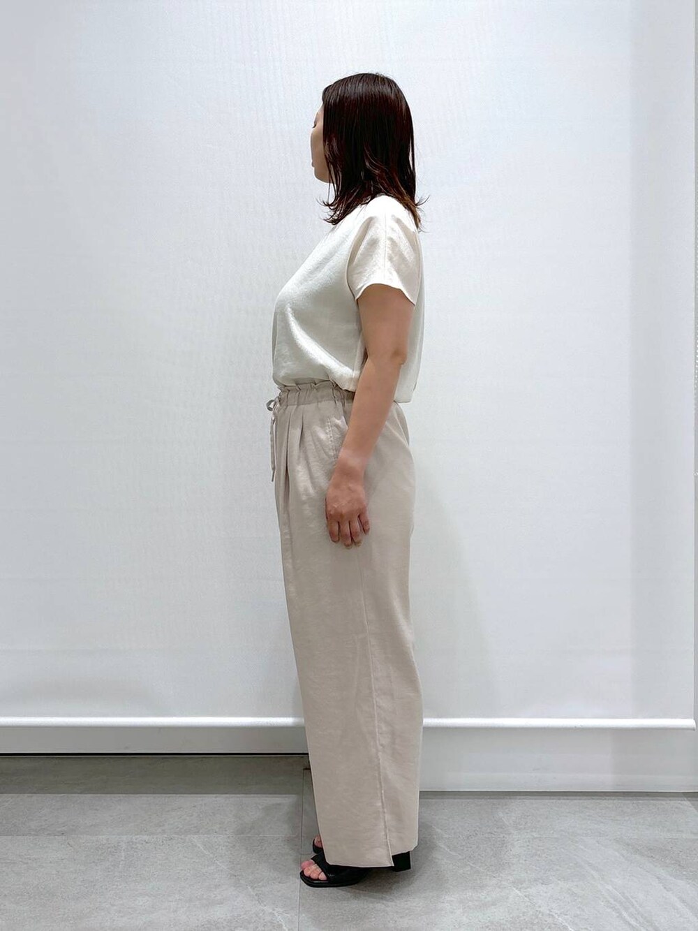 ブラック系のサンダル、ブラック系のハンドバッグ、ベージュ系のその他パンツを着用したレディースの夏コーディネートの3枚目の写真