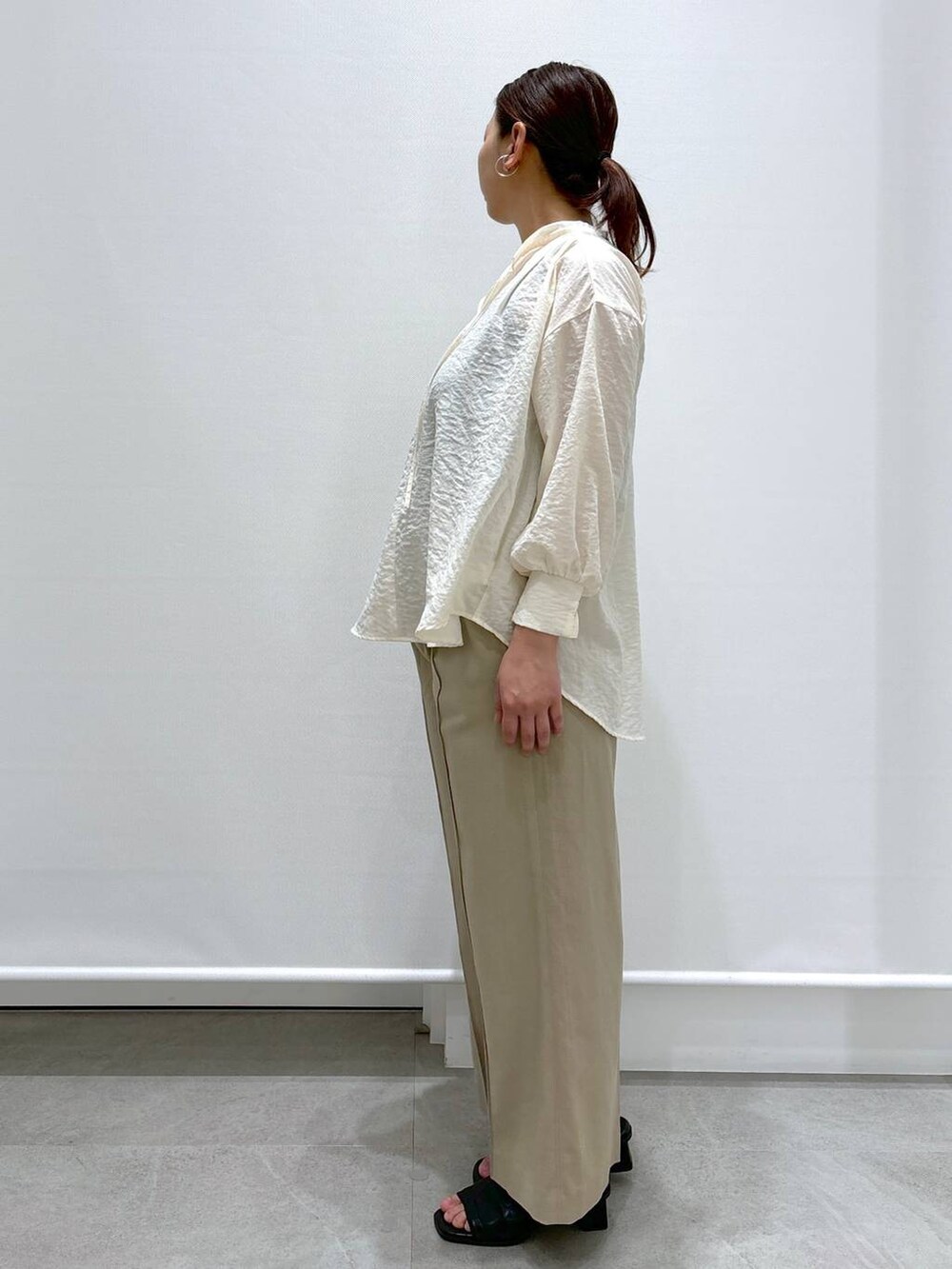 ベージュ系のその他パンツ、ブラック系のショルダーバッグ、ホワイト系のシャツ/ブラウスを着用したレディースの春コーディネートの3枚目の写真