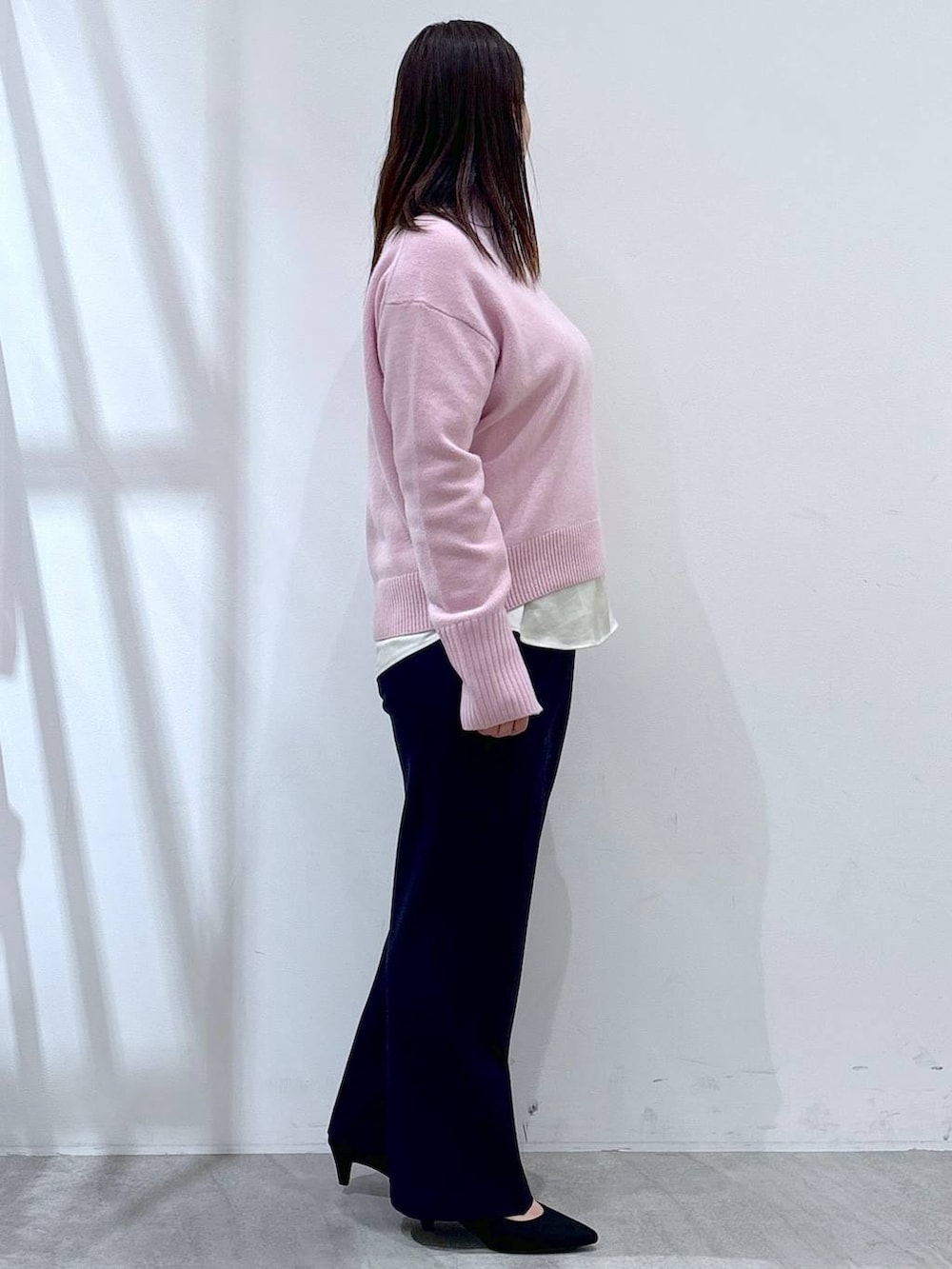 ピンク系のニット/セーター、ホワイト系のシャツ/ブラウス、ブラック系のパンプスを着用したレディースの冬コーディネートの4枚目の写真