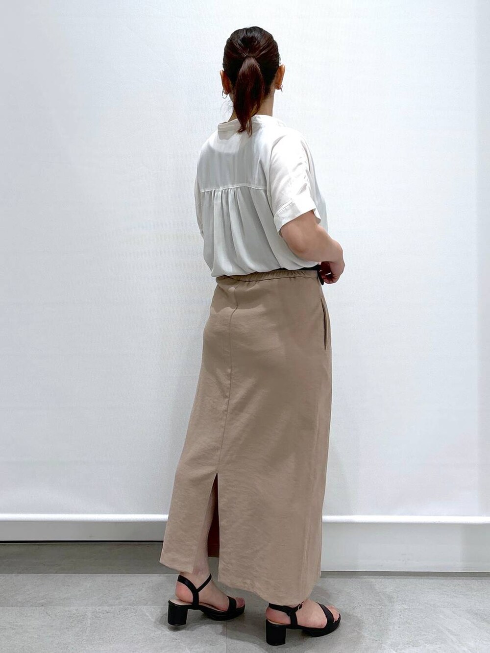 ブラック系のカーディガン/ボレロ、ホワイト系のシャツ/ブラウス、ブラック系のハンドバッグを着用したレディースの夏コーディネートの6枚目の写真