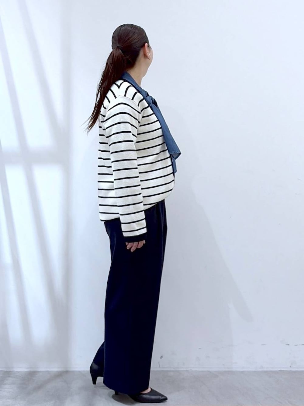 ブラック系のハンドバッグ、ブルー系のその他パンツ、ホワイト系のカーディガン/ボレロを着用したレディースの春コーディネートの6枚目の写真