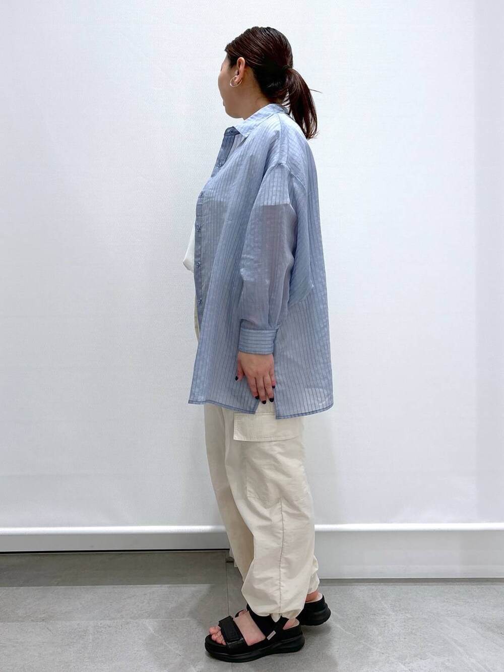 ホワイト系のTシャツ/カットソー、ブラック系のサンダル、ブラック系のハンドバッグを着用したレディースの春コーディネートの3枚目の写真