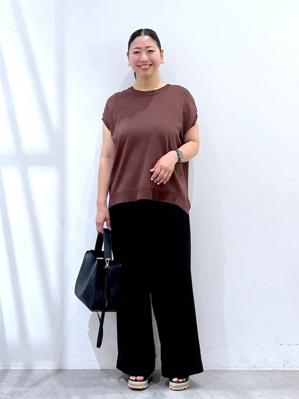 ブラック系のその他パンツ、ブラック系のハンドバッグ、ブラウン系のニット/セーターを着用したレディースの夏コーディネートの2枚目の写真