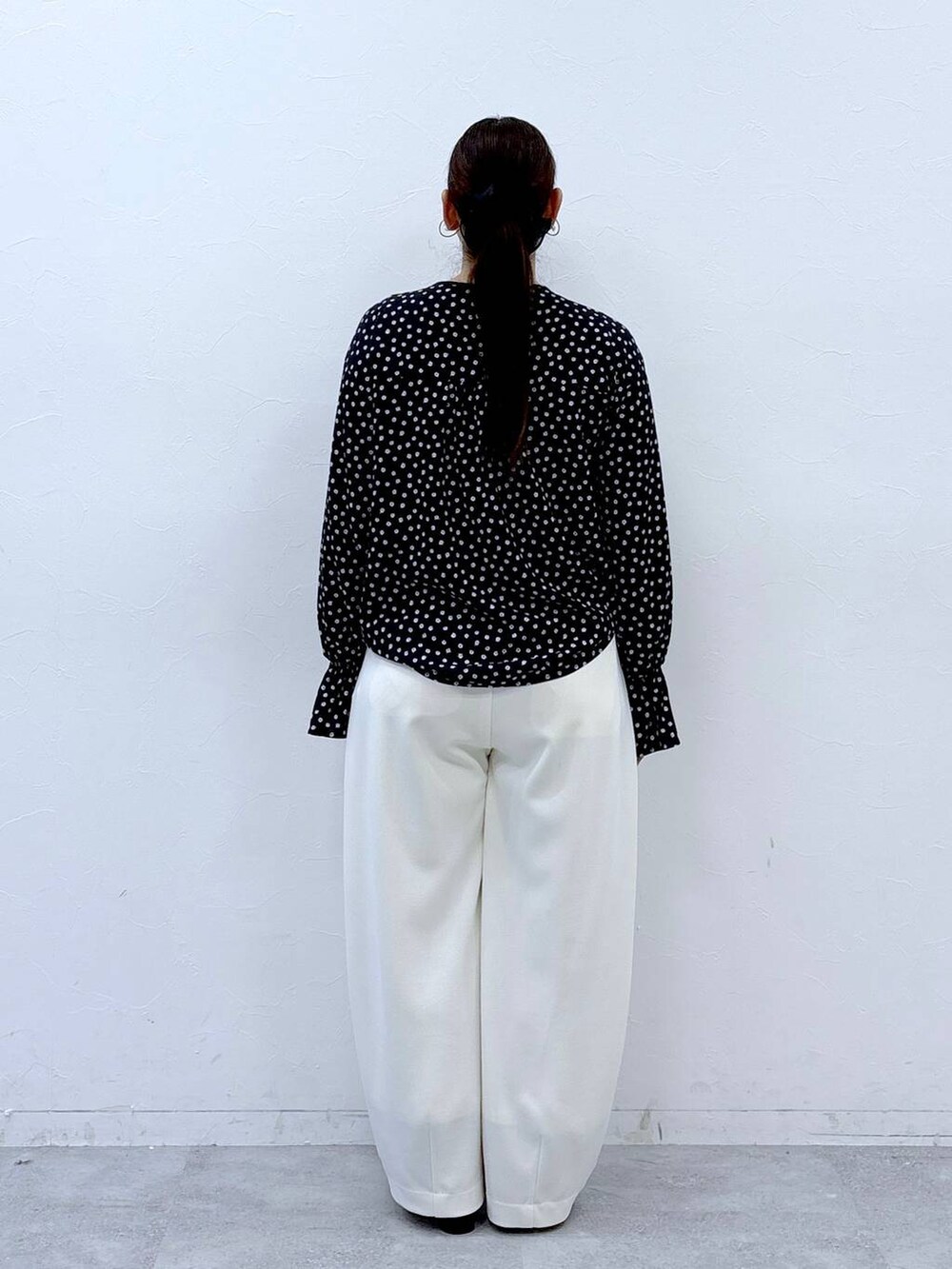 ブラック系のハンドバッグ、ブラック系のパンプス、ブラック系のシャツ/ブラウスを着用したレディースの冬コーディネートの4枚目の写真