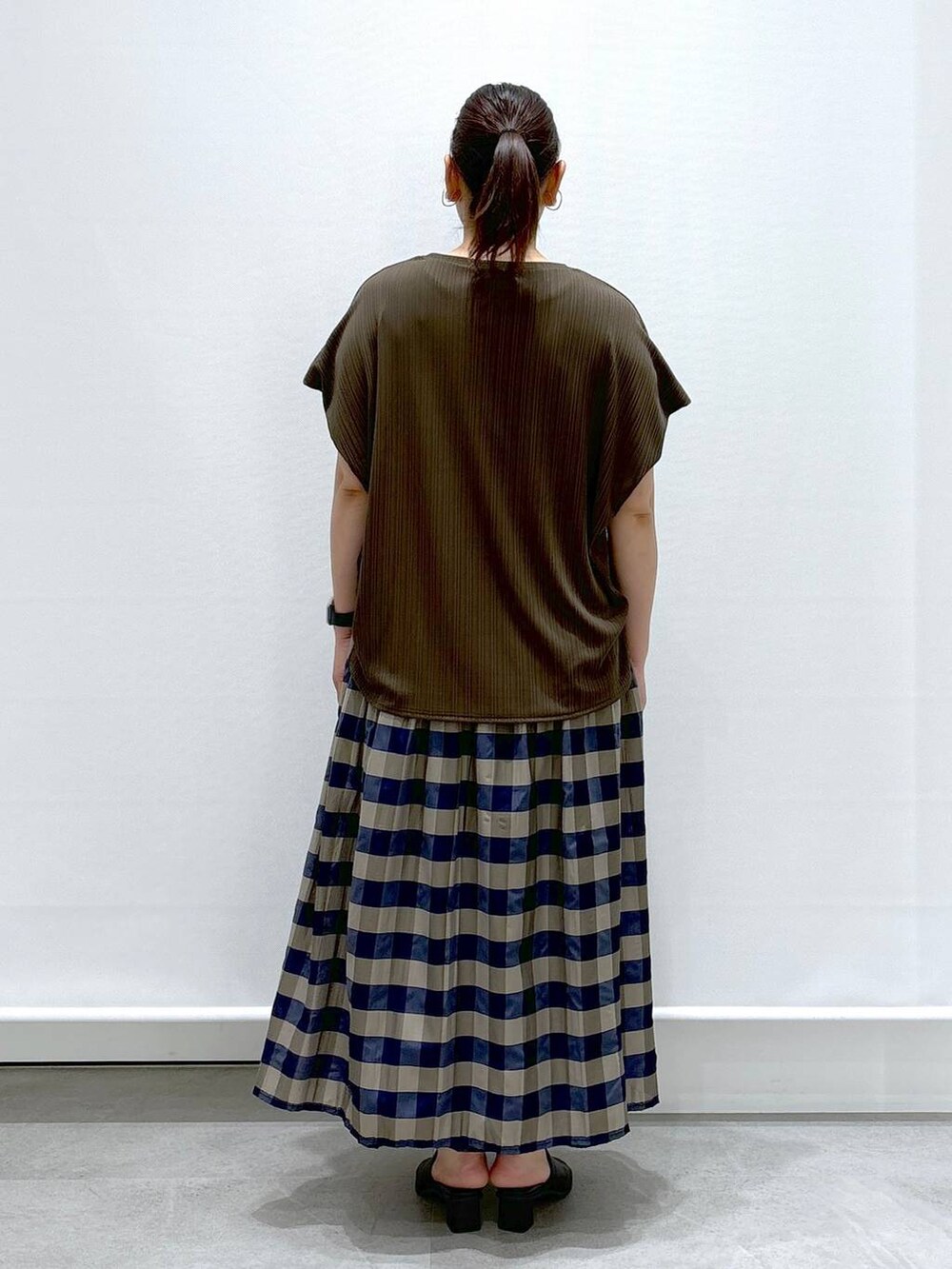 ブラック系のサンダル、グリーン系のTシャツ/カットソー、グリーン系のスカートを着用したレディースの夏コーディネートの5枚目の写真