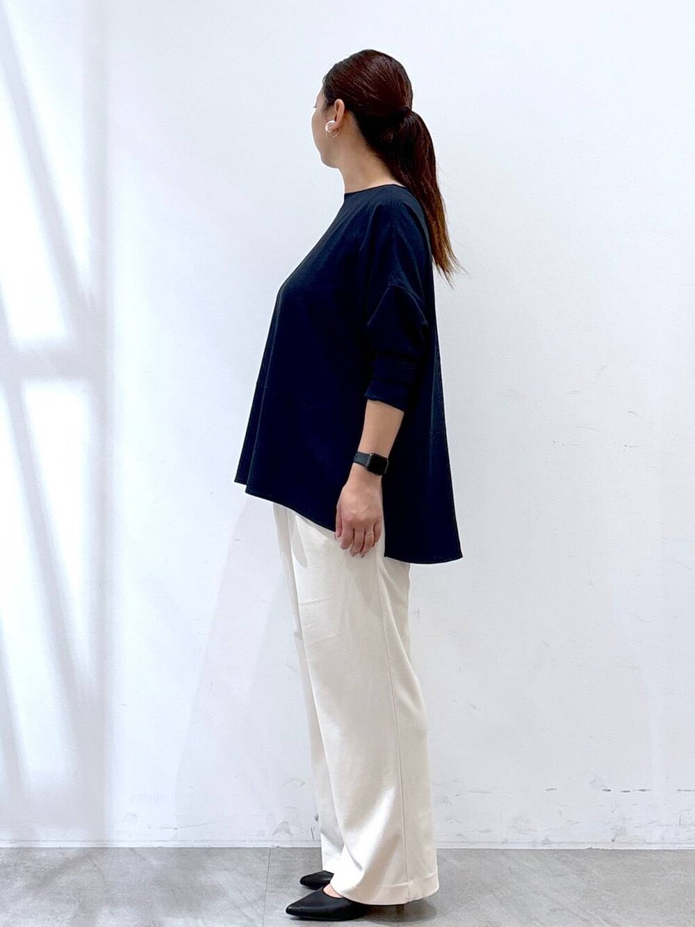 ブラック系のパンプス、ブルー系のシャツ/ブラウス、ブラック系のショルダーバッグを着用したレディースの秋コーディネートの3枚目の写真