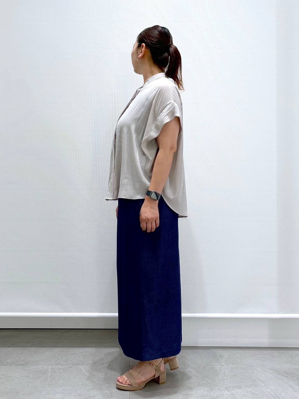 ベージュ系のシャツ/ブラウス、ベージュ系のサンダル、ブルー系のデニムスカートを着用したレディースの夏コーディネートの3枚目の写真