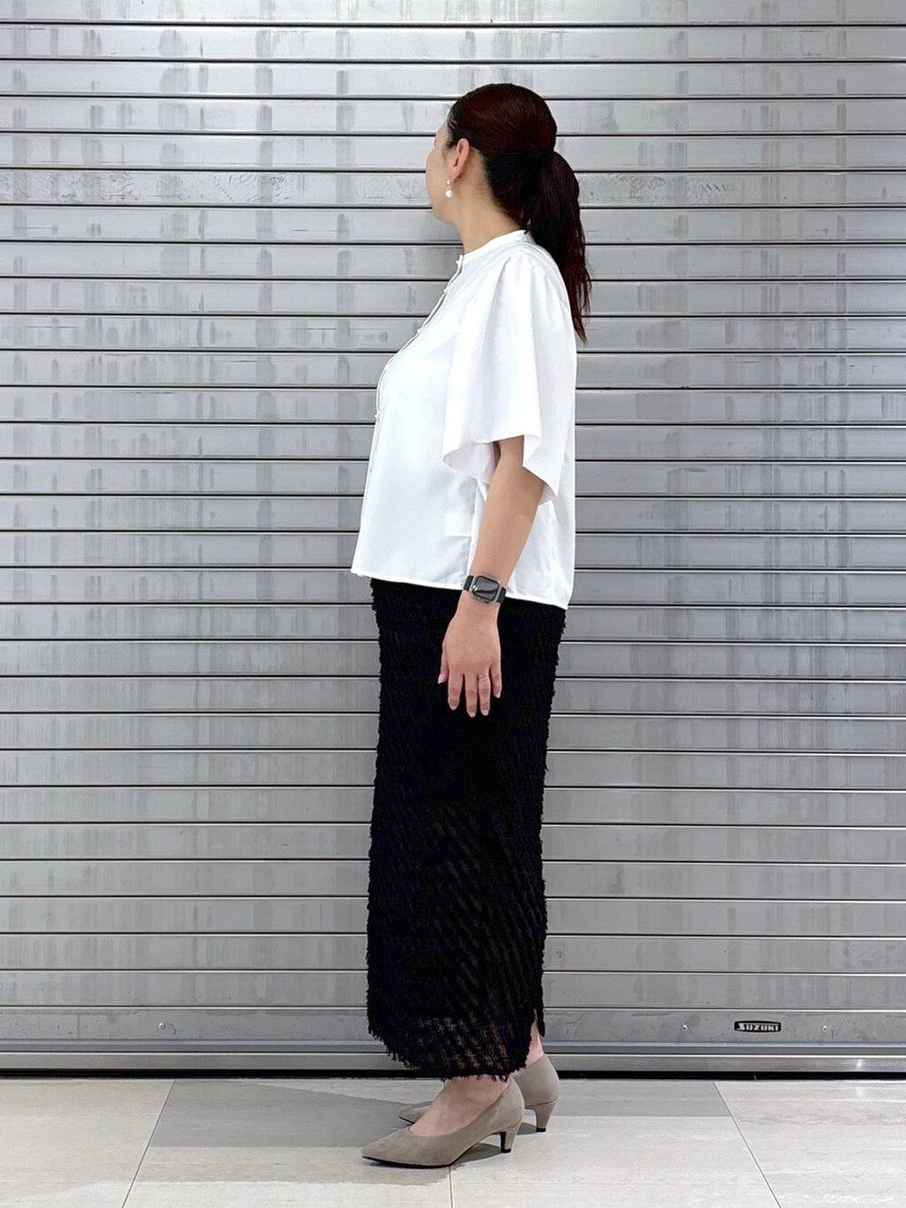 ベージュ系のパンプス、ベージュ系のハンドバッグを着用したレディースの春コーディネートの3枚目の写真