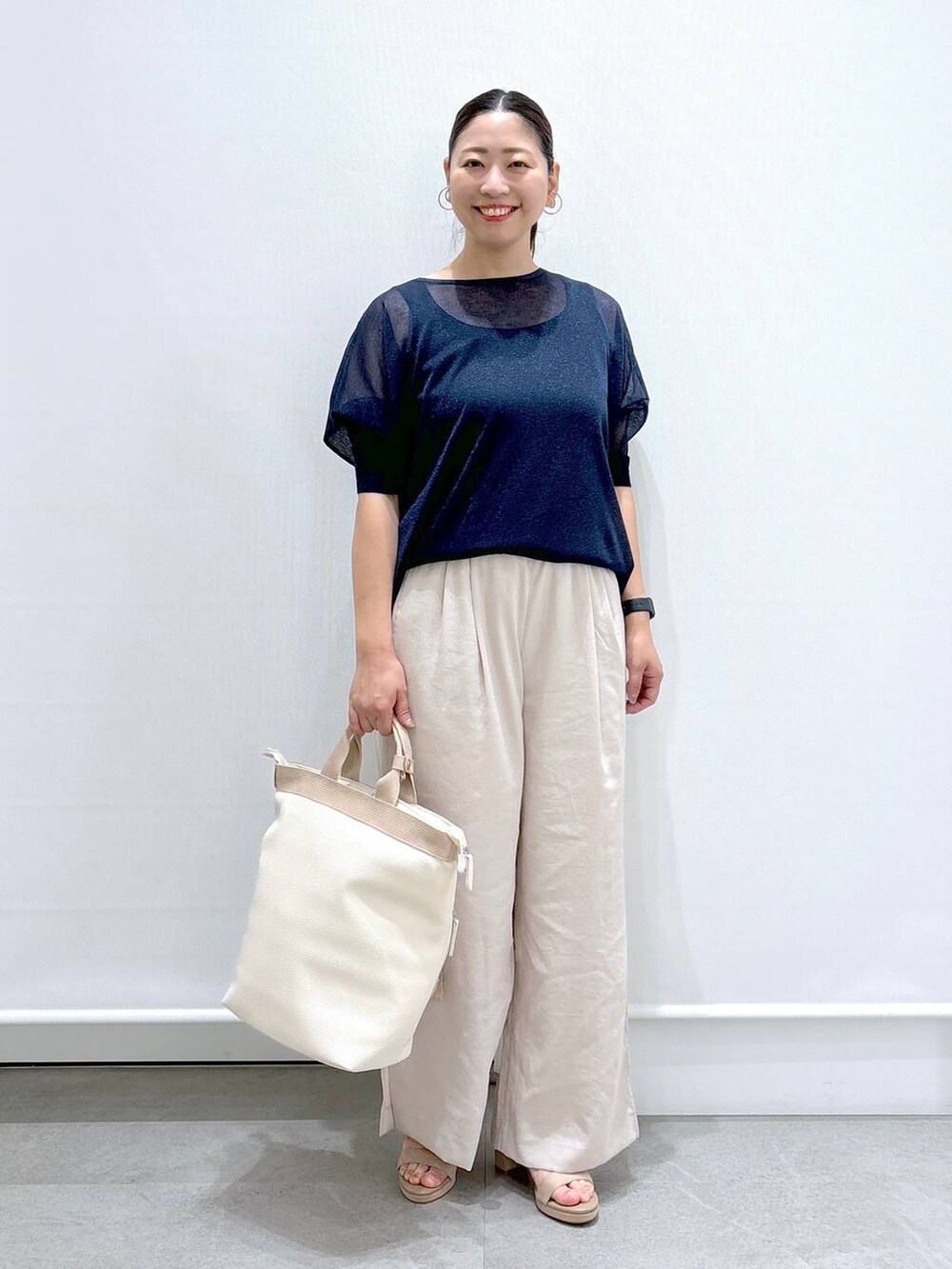 ベージュ系のその他パンツ、ベージュ系のサンダル、ブルー系のニット/セーターを着用したレディースの夏コーディネートの2枚目の写真