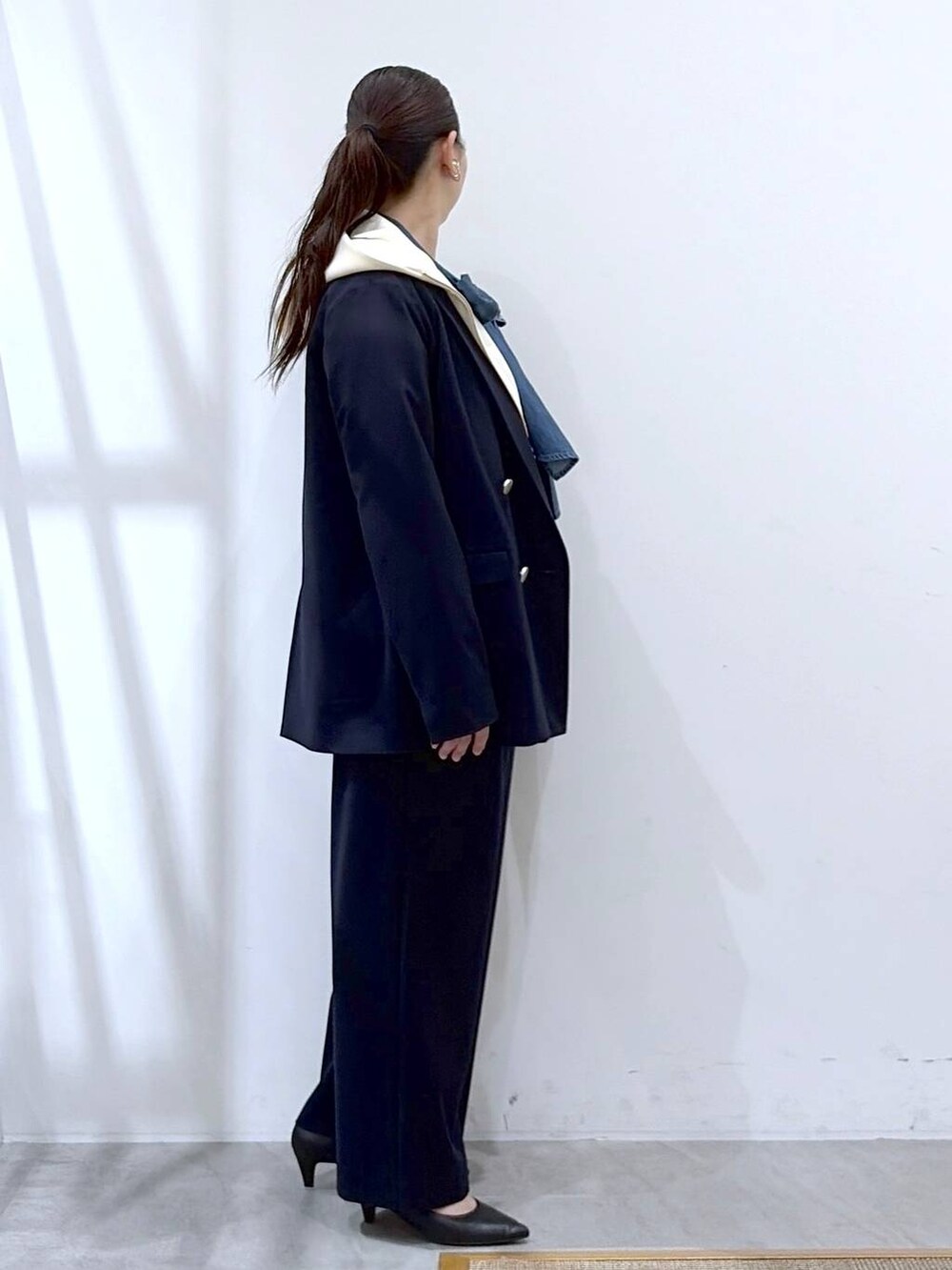 ブラック系のハンドバッグ、ホワイト系のパーカー、ブルー系のその他パンツを着用したレディースの春コーディネートの5枚目の写真