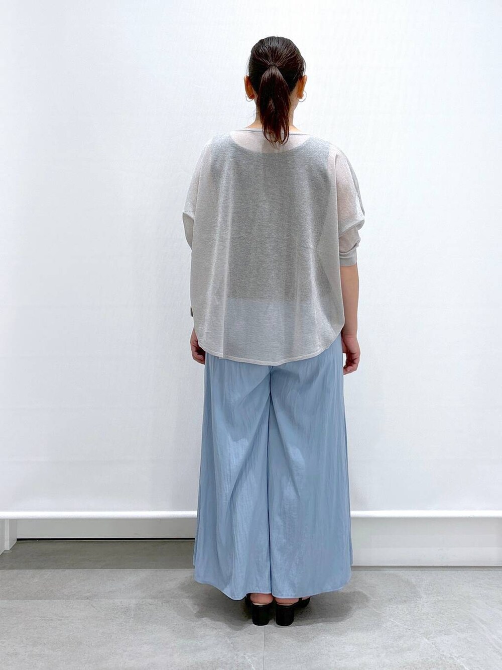 グレー系のニット/セーター、ブルー系のその他パンツ、ブラック系のサンダルを着用したレディースの夏コーディネートの4枚目の写真