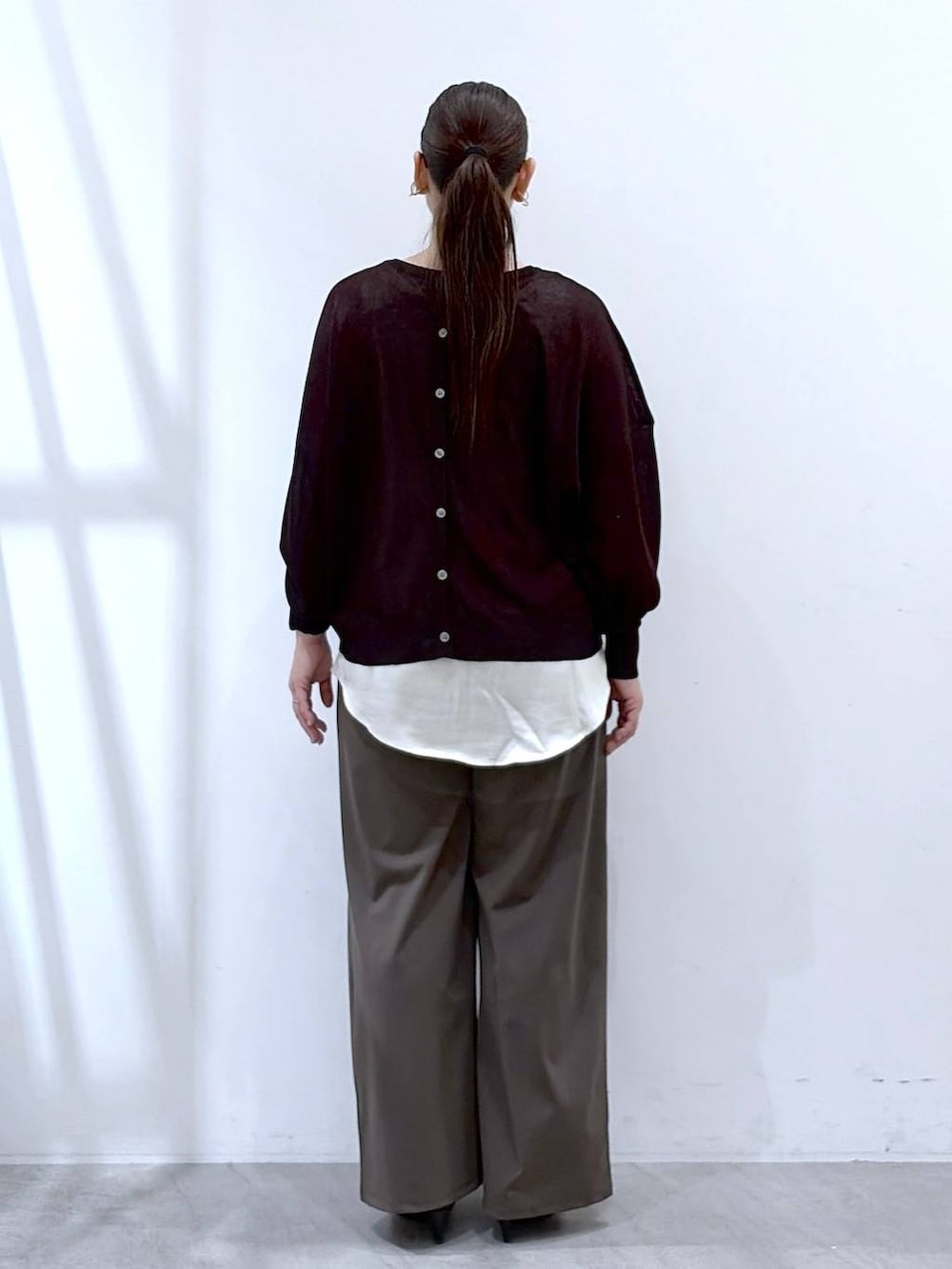 ブラック系のハンドバッグ、グリーン系のその他パンツ、ホワイト系のタンクトップを着用したレディースの春コーディネートの4枚目の写真