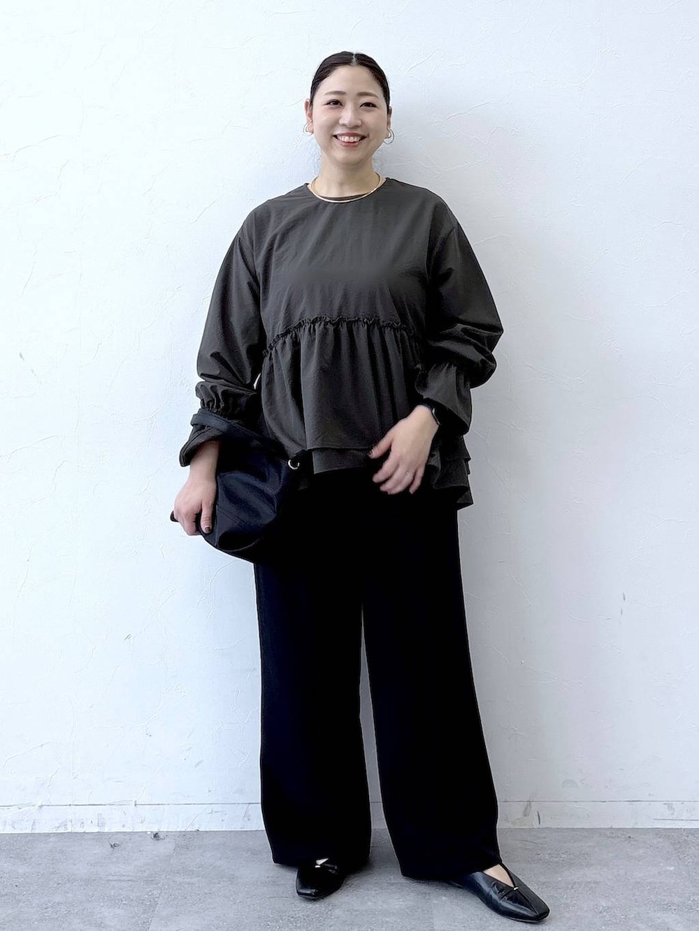 ブラック系のトートバッグ、ブラック系のパンプス、ブラウン系のシャツ/ブラウスを着用したレディースの冬コーディネートの2枚目の写真