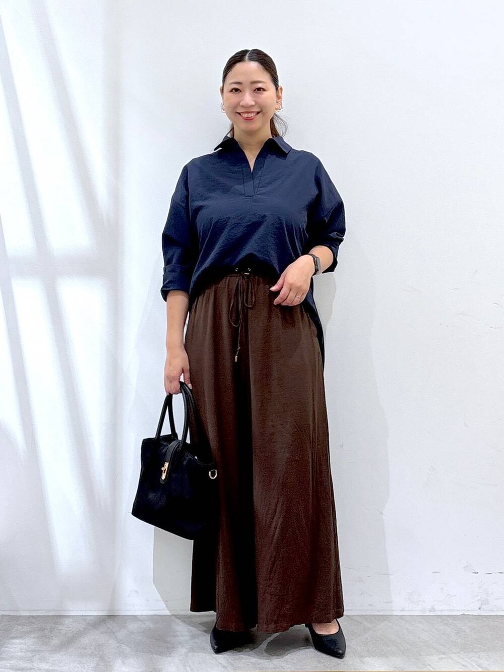 ブラック系のパンプス、ブラウン系のその他パンツ、ブルー系のシャツ/ブラウスを着用したレディースの秋コーディネートの2枚目の写真