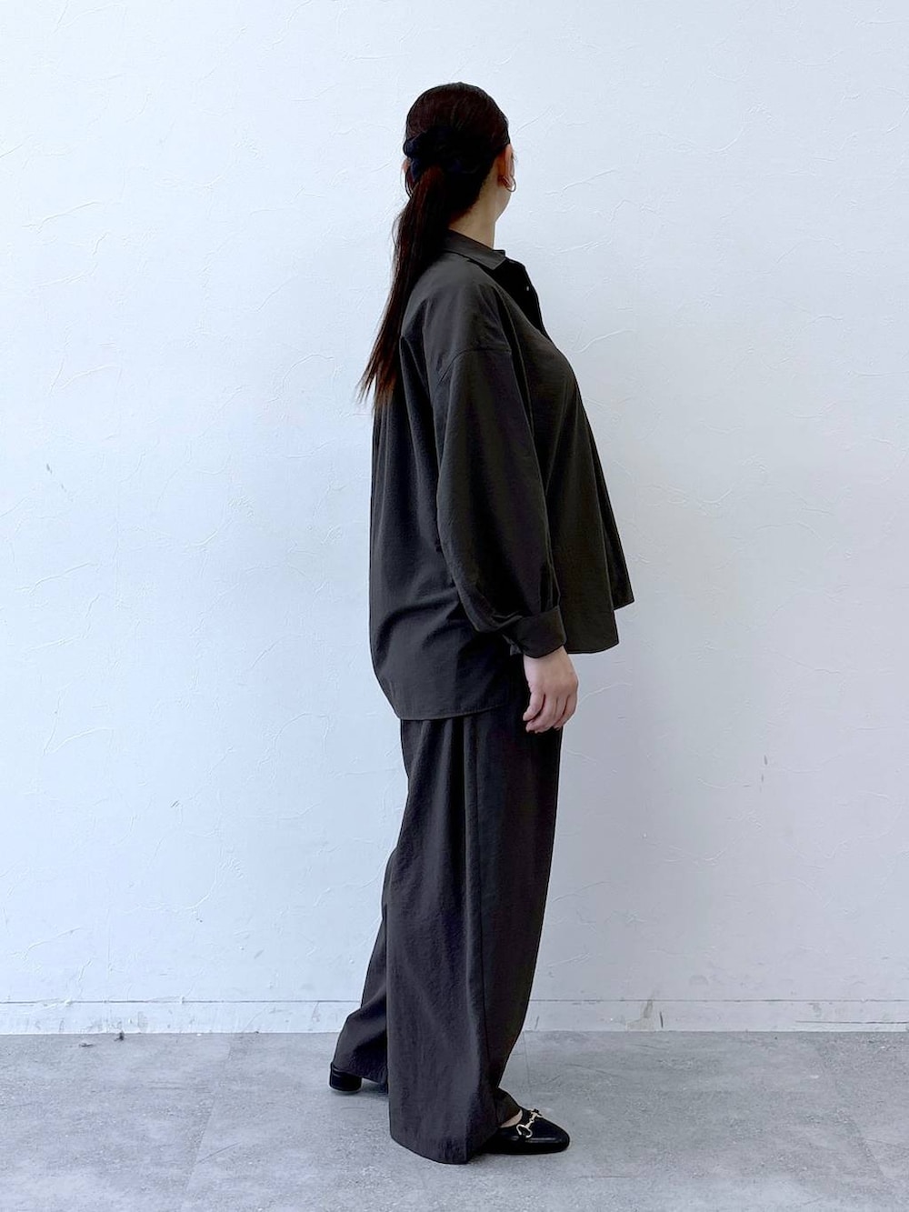 ブラック系のハンドバッグ、ブラック系のパンプス、ブラウン系のシャツ/ブラウスを着用したレディースの冬コーディネートの4枚目の写真