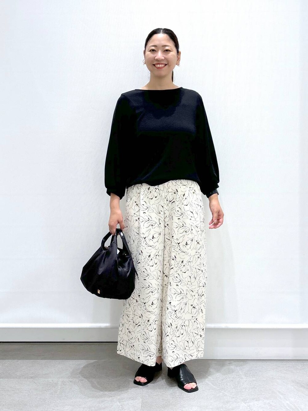 ブラック系のサンダル、ブラック系のその他パンツ、ブラック系のTシャツ/カットソーを着用したレディースの夏コーディネートの2枚目の写真