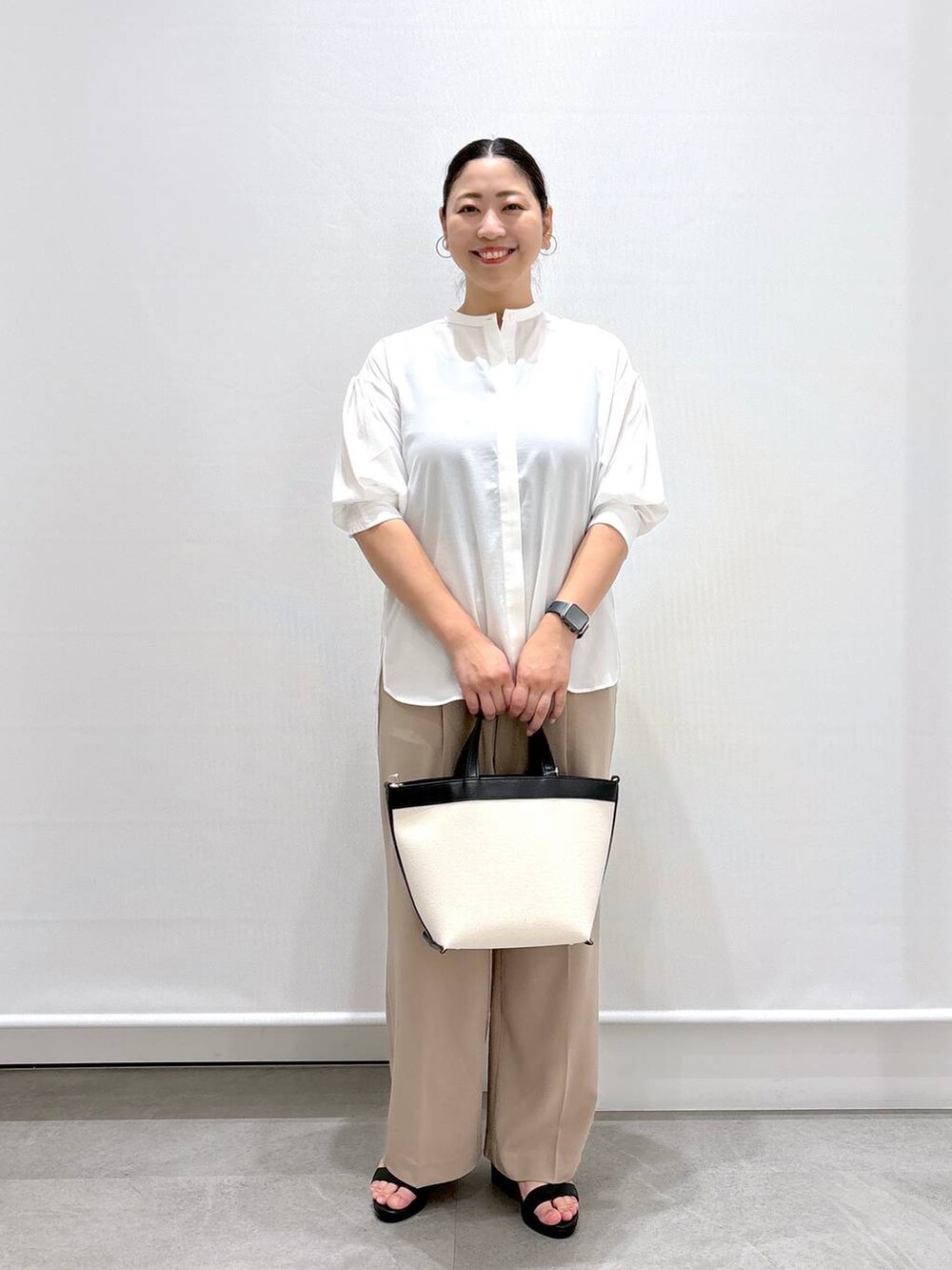 ベージュ系のその他パンツ、ブラック系のサンダル、ホワイト系のシャツ/ブラウスを着用したレディースの夏コーディネートの2枚目の写真