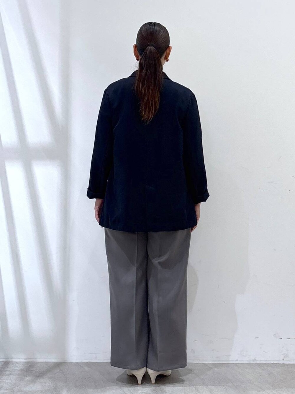 ホワイト系のパンプス、グレー系のその他パンツ、ブルー系のテーラードジャケットを着用したレディースの秋コーディネートの4枚目の写真