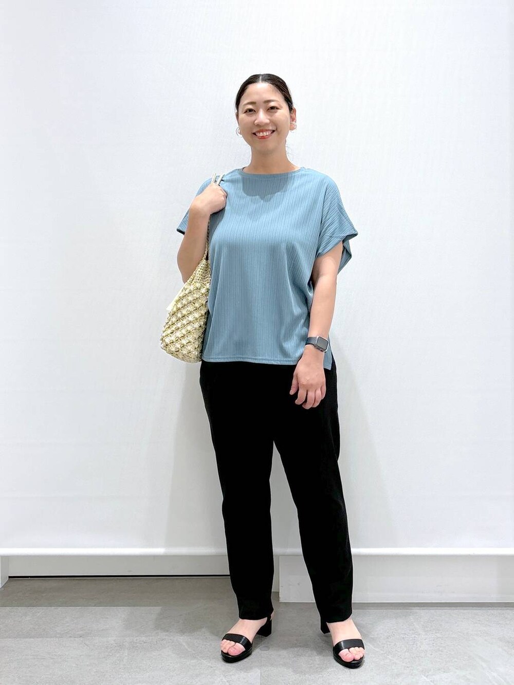 ゴールド系のトートバッグ、ブラック系のその他パンツ、グリーン系のTシャツ/カットソーを着用したレディースの秋コーディネートの2枚目の写真