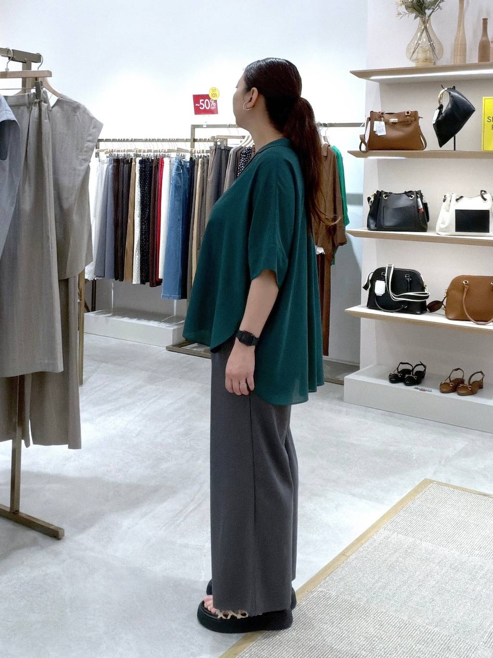 グレー系のその他パンツ、グリーン系のシャツ/ブラウス、ブラック系のタンクトップを着用したレディースの夏コーディネートの3枚目の写真