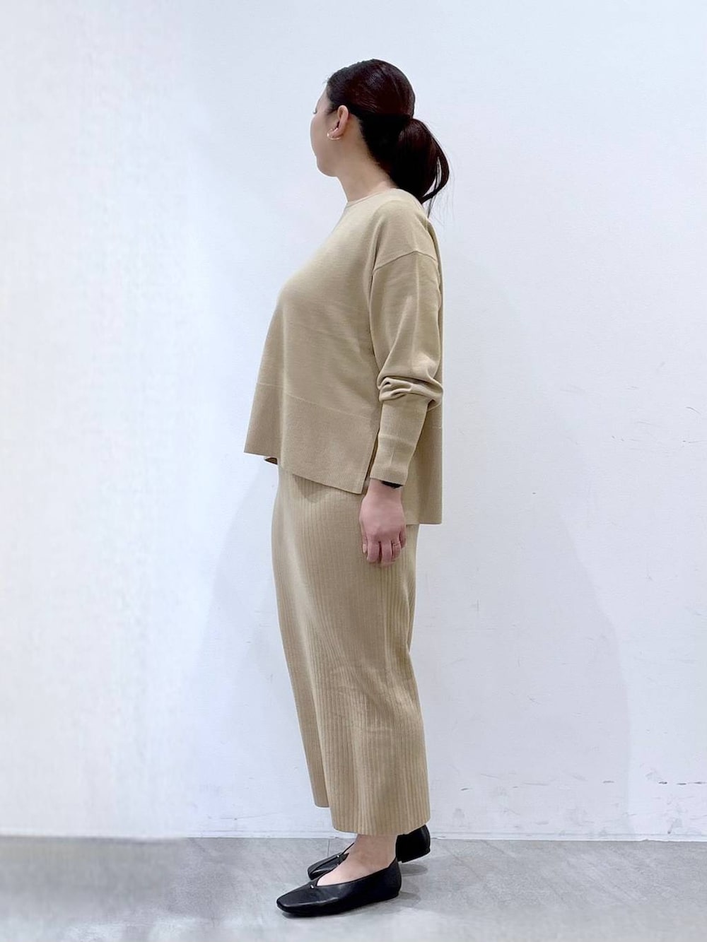 ベージュ系のニット/セーター、ベージュ系のスカート、ブラック系のパンプスを着用したレディースの冬コーディネートの3枚目の写真