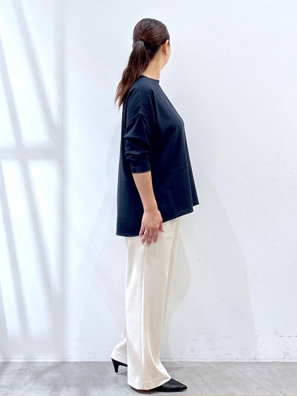 ブラック系のパンプス、ブルー系のシャツ/ブラウス、ブラック系のショルダーバッグを着用したレディースの秋コーディネートの5枚目の写真