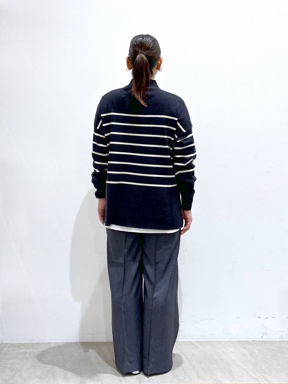 シルバー系のローファー、ブルー系のニット/セーター、ブルー系のデニムパンツを着用したレディースの秋コーディネートの4枚目の写真